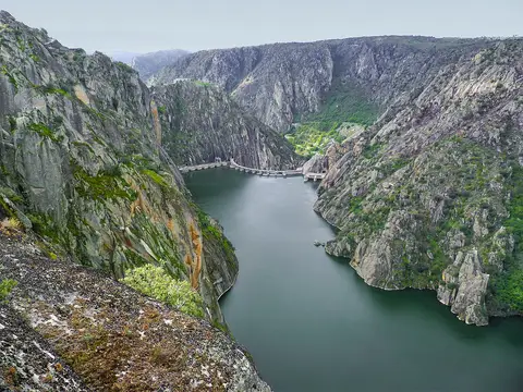 Vista do miradouro sobre as arribas do Douro, com o rio encaixado entre falésias e a barragem ao fundo