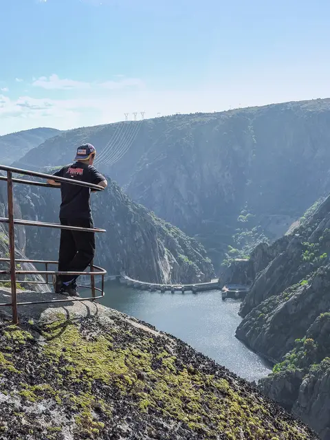 Miradouro com guarda-corpos sobre o desfiladeiro do rio Douro, com uma pessoa de costas a observar