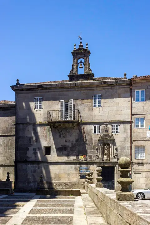 Fachada em pedra do Museu Diocesano de Tui, com campanário e varanda, sob céu azul