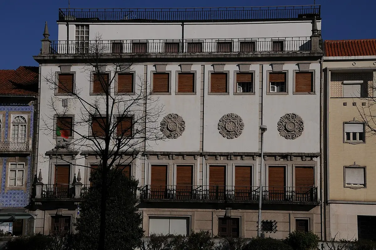 Fachada branca do Museu Nogueira da Silva, em Braga, com rosáceas em relevo e bandeira portuguesa
