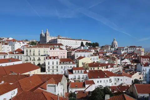 Vista sobre os telhados da Alfama a partir do Miradouro de Santa Luzia, com São Vicente de Fora ao fundo