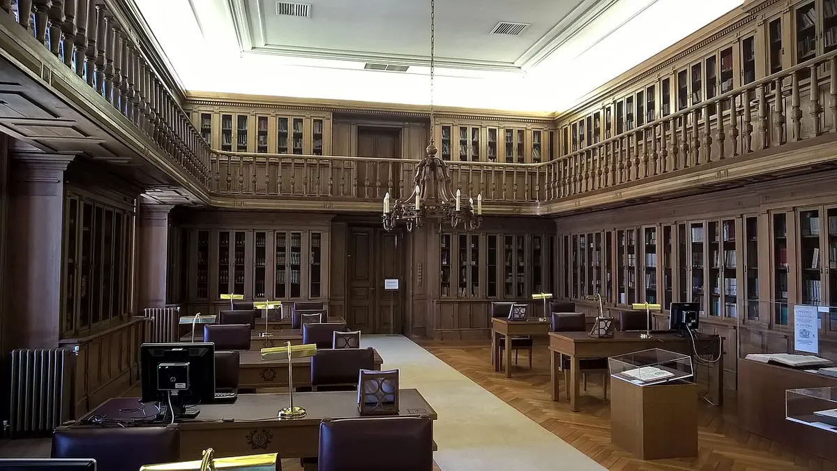 Sala de leitura em madeira da Biblioteca Passos Manuel, com estantes, galeria superior e lustre