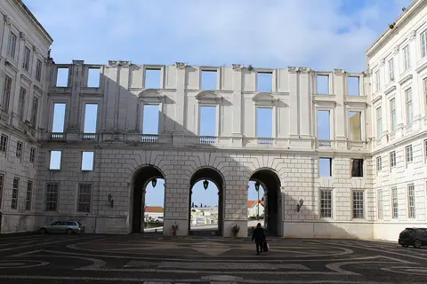 Fachada inacabada do Palácio Nacional da Ajuda com arcadas e pátio em calçada portuguesa
