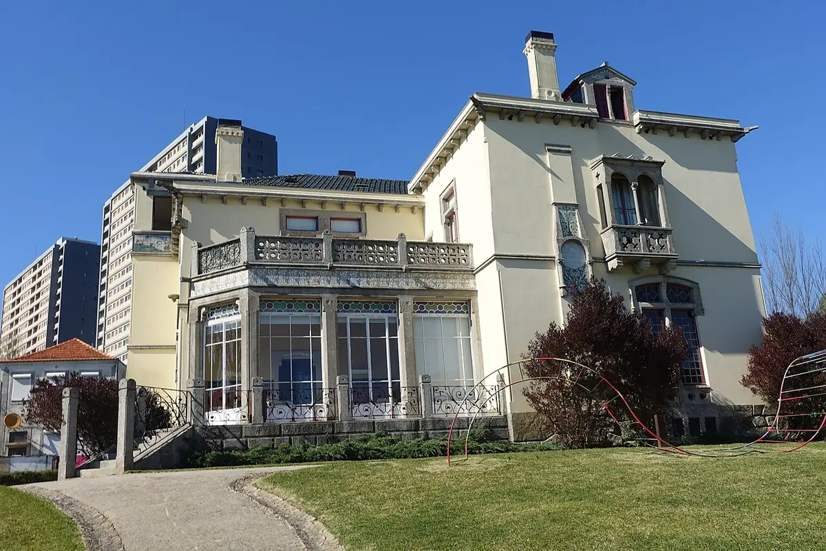 Fachada da Casa-Museu da Quinta de Santiago, com varanda envidraçada e jardim relvado
