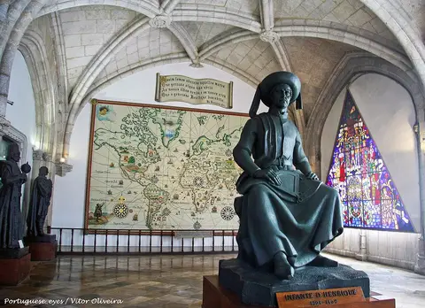 Interior do Museu de Marinha com estátua do Infante D. Henrique, mapa antigo e vitral