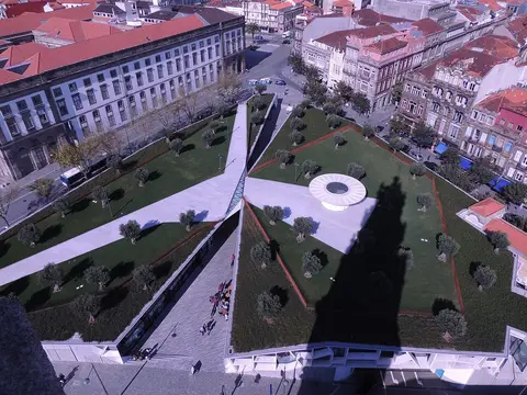 Vista aérea da praça dos Clérigos, no Porto, com jardins, oliveiras e edifícios em redor