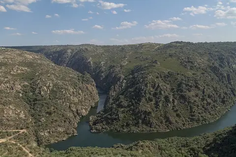 Vista do miradouro da Fraga do Puio sobre o cânion do rio Douro, com encostas rochosas e vegetação.