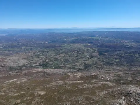 Vista aérea da Serra do Larouco, com planalto rochoso e vales ao fundo sob céu azul