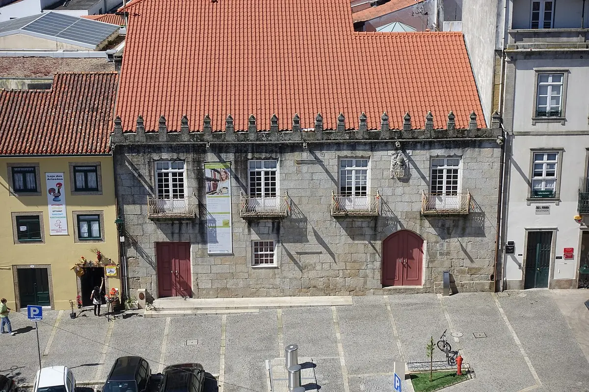 Fachada em granito da Biblioteca Municipal de Barcelos, com varandas e telhado vermelho, vista do alto.