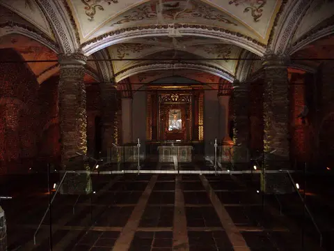 Interior da Capela dos Ossos, em Évora, com colunas revestidas de ossos e altar dourado ao fundo