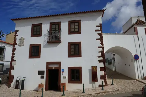 Fachada branca com cantarias vermelhas da Casa-Museu João de Deus, em São Bartolomeu de Messines