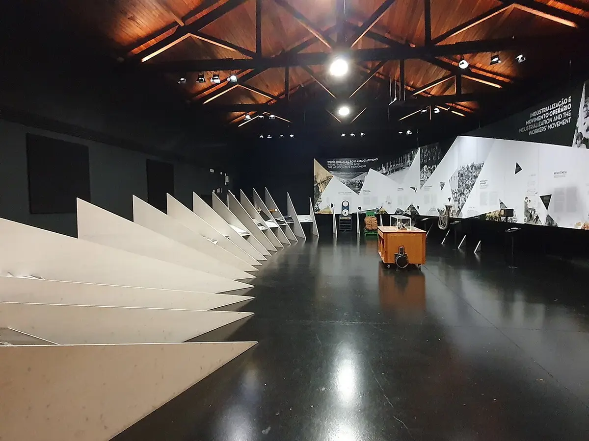 Sala expositiva do Espaço Memória, no Barreiro, com painéis e teto de madeira