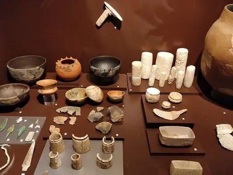 Vitrina do museu com cerâmicas, pesos e objetos arqueológicos expostos