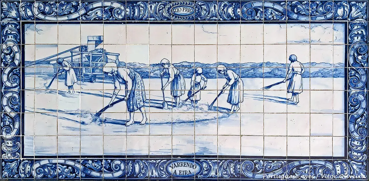 Painel de azulejos azuis e brancos com cena agrícola "Varrendo a Eira", na estação do Pinhal Novo