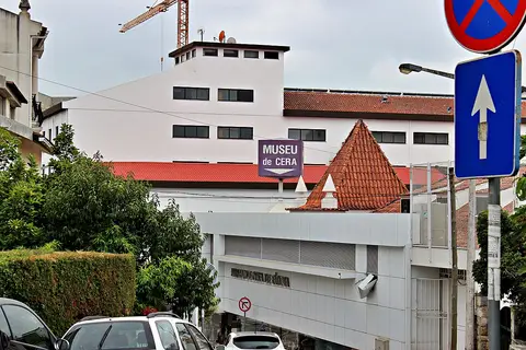 Exterior do Museu de Cera de Fátima com letreiro roxo e telhados vermelhos