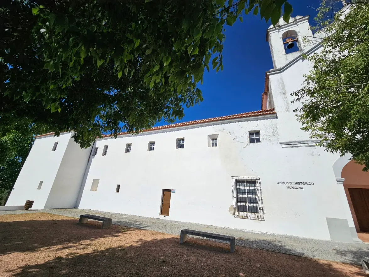 Fachada branca do Arquivo Histórico Municipal de Elvas, no antigo Convento de São Francisco, com torre sineira.
