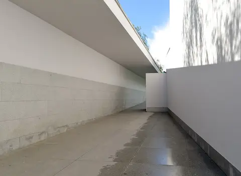Corredor exterior de betão branco e granito na Fundação de Serralves, no Porto.