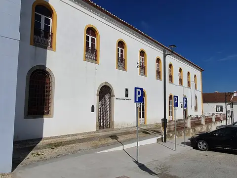Fachada branca com janelas em arco do edifício da Biblioteca Municipal Almeida Faria, em Montemor-o-Novo
