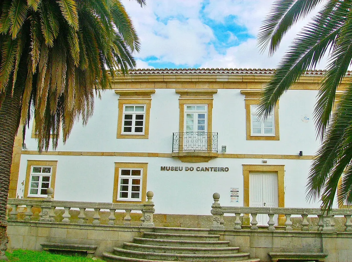 Fachada branca do Museu do Canteiro, com cantarias em pedra, varanda de ferro e escadaria, entre palmeiras.