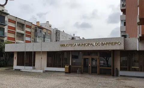 Entrada da Biblioteca Municipal do Barreiro, com letreiro na fachada e prédios em redor