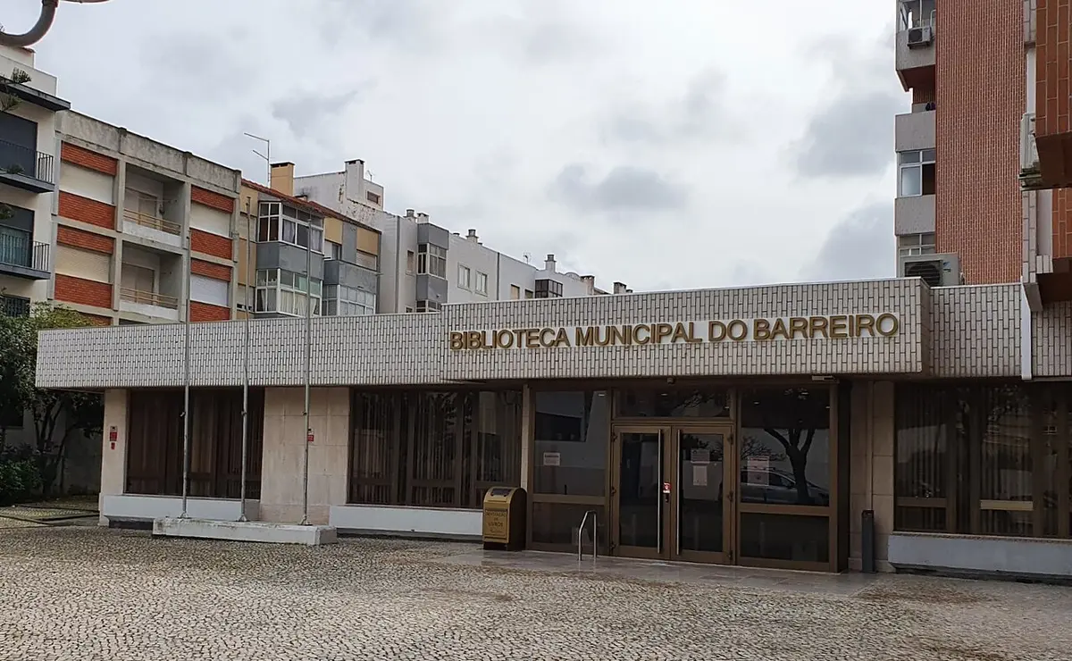 Entrada da Biblioteca Municipal do Barreiro, com letreiro na fachada e prédios em redor