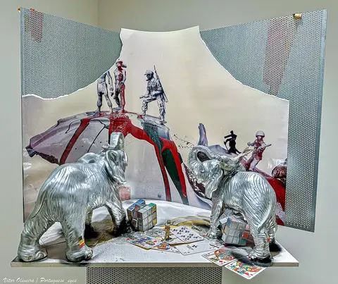 Instalação artística com elefantes prateados, cubos mágicos e figuras militares, num museu de arte contemporânea