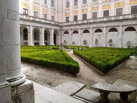 Claustro do Palácio Nacional de Mafra com jardim de buxo e arcadas em pedra