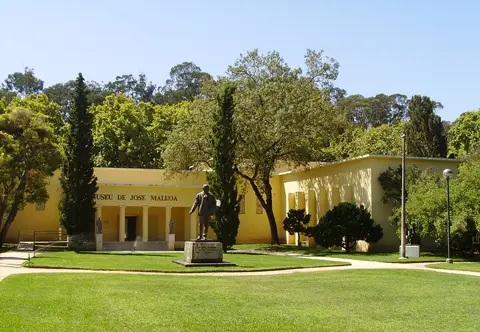 Edifício amarelo do Museu de José Malhoa, com estátua e relvado no Parque D. Carlos I