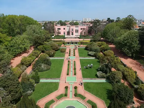 Vista aérea dos jardins de Serralves com espelhos de água, sebes e a Casa de Serralves ao fundo