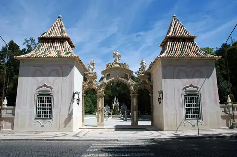 Portal barroco do Jardim da Sereia, com torreões e estátuas, à entrada do Parque de Santa Cruz
