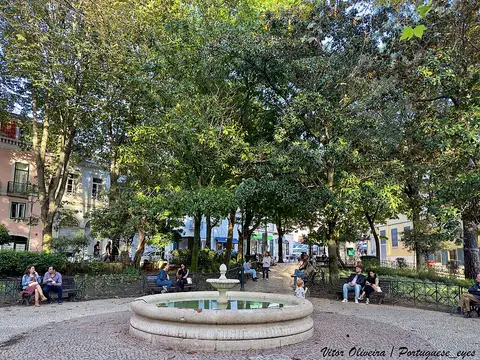 Jardim Fialho de Almeida em Lisboa, com fonte de pedra, calçada portuguesa e árvores frondosas