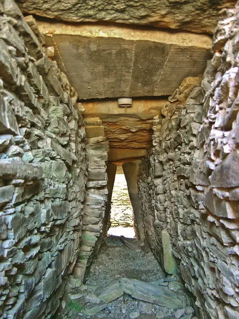 Corredor de pedra no interior de um monumento megalítico de Alcalar, com lajes de xisto nas paredes