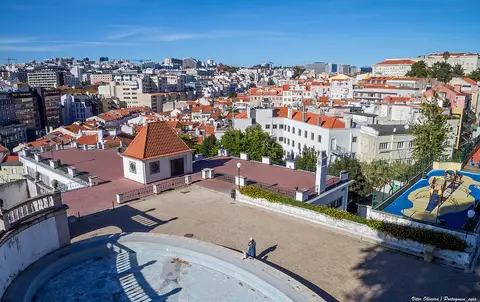 Vista do miradouro do Jardim do Torel sobre os telhados de Lisboa, com parque infantil ao lado