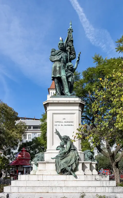 Estátua em bronze do Marquês de Sá da Bandeira sobre pedestal de pedra, rodeada de árvores, em Lisboa