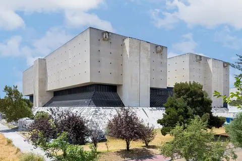 Fachada de betão do Arquivo Nacional da Torre do Tombo, em Lisboa, rodeada de árvores
