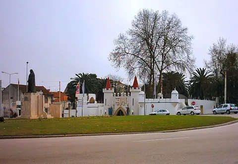 Entrada do Portugal dos Pequenitos, em Coimbra, com muralhas e torres brancas junto à rotunda
