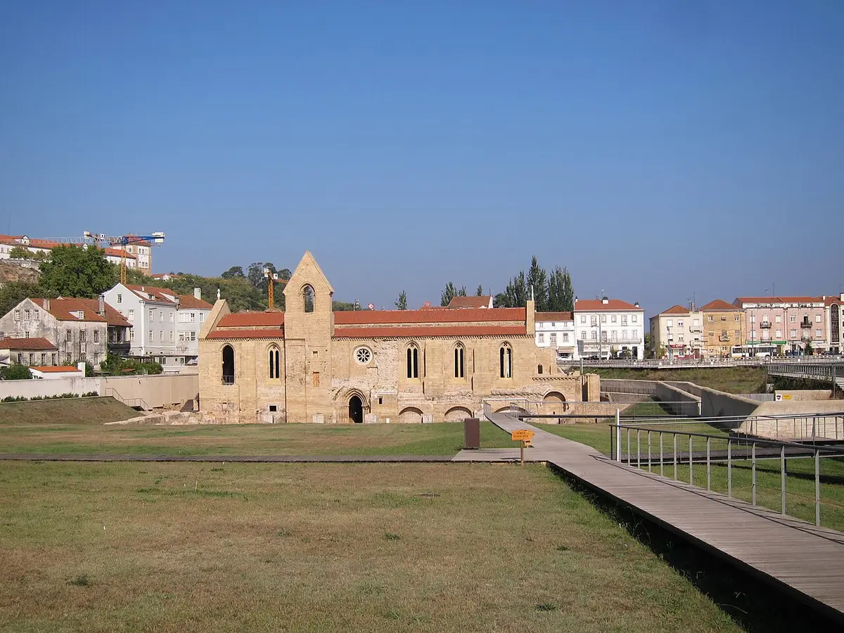 Mosteiro de Santa Clara-a-Velha em Coimbra, com passadiço de madeira e relvado em primeiro plano