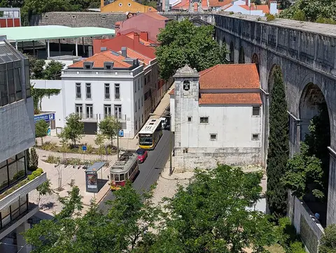 Vista do alto do Aqueduto das Águas Livres junto às Amoreiras, com elétrico e autocarro na rua.