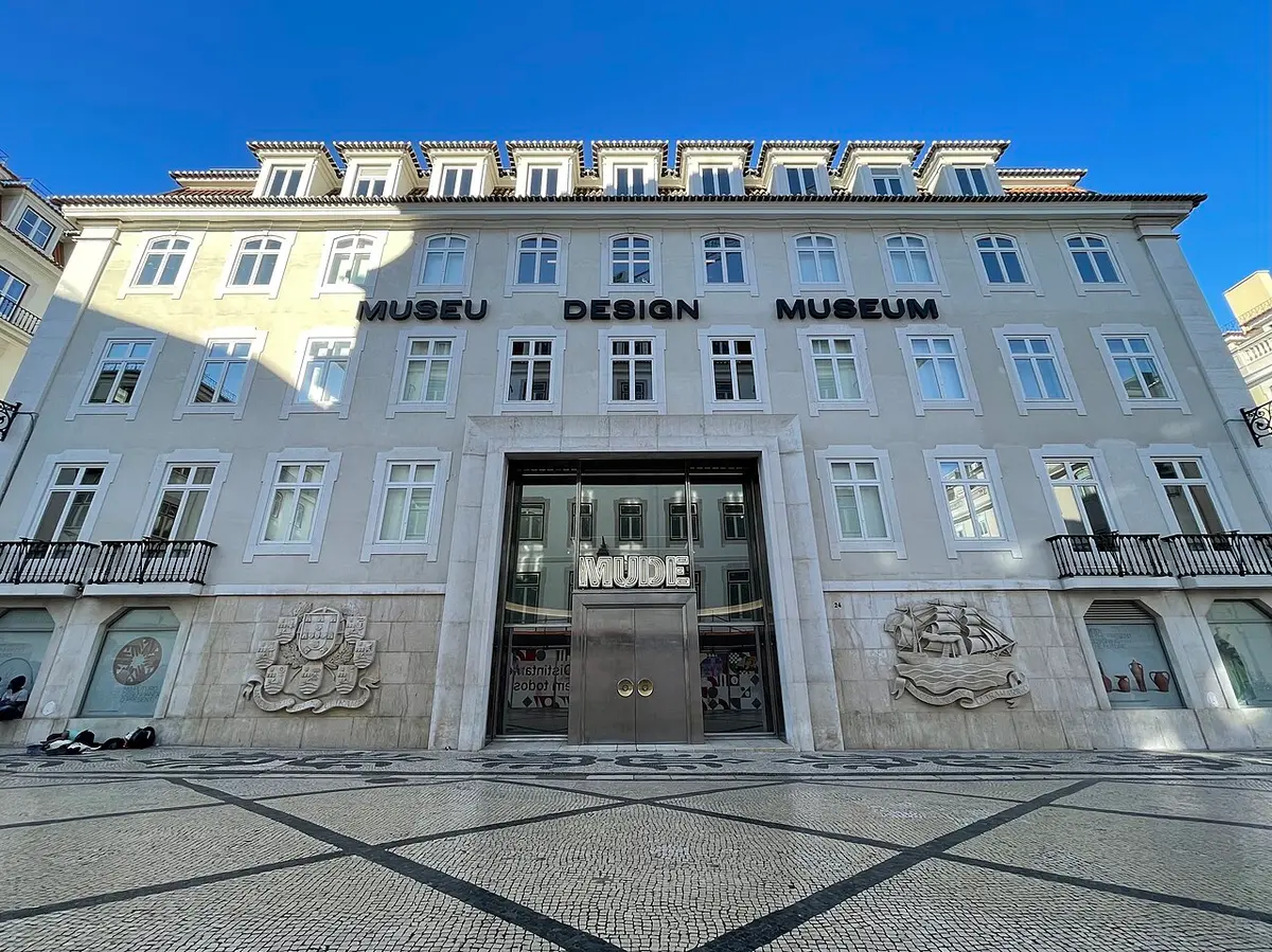 Fachada do MUDE – Museu do Design, em Lisboa, com letreiro e calçada portuguesa em frente