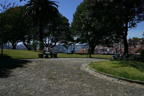 Jardim do Morro com árvores, banco de pedra e vista sobre o Porto e o rio Douro