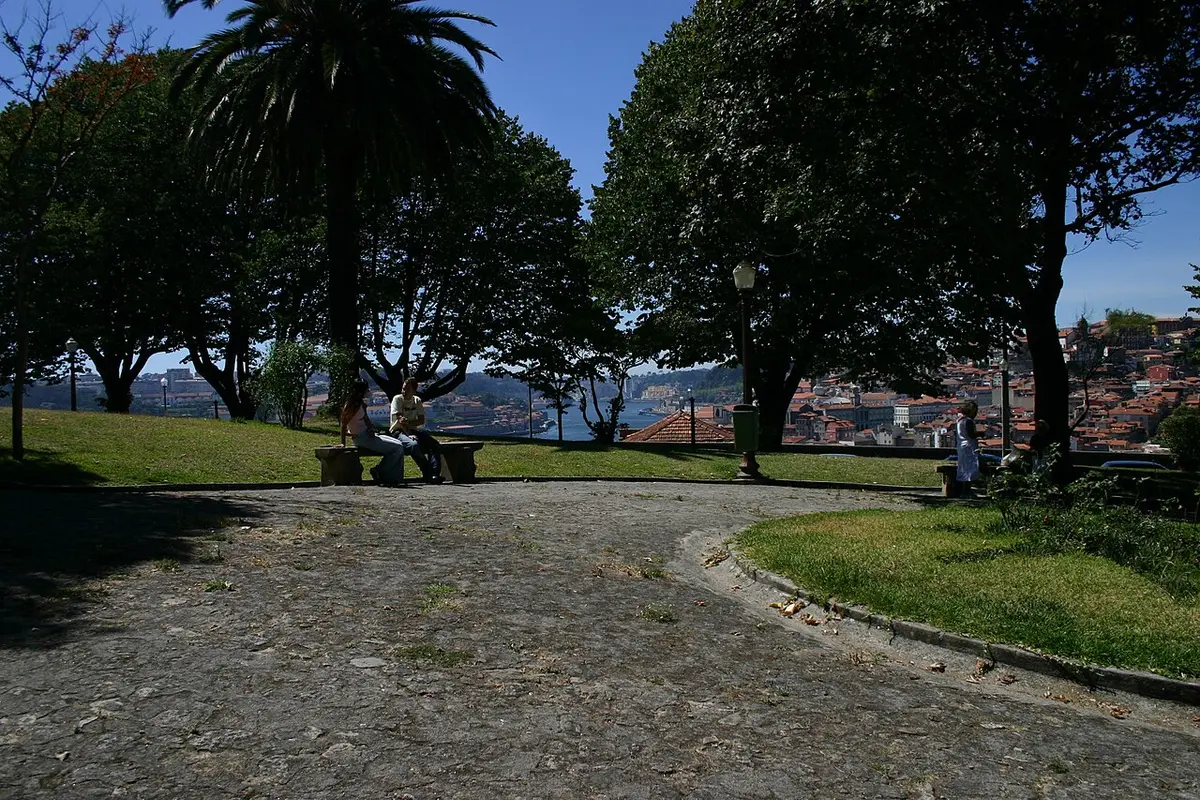Jardim do Morro com árvores, banco de pedra e vista sobre o Porto e o rio Douro