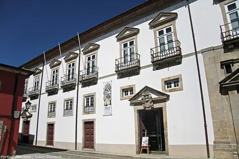 Fachada branca do Arquivo Municipal Alfredo Pimenta, em Guimarães, com varandas de ferro e portal com brasão.