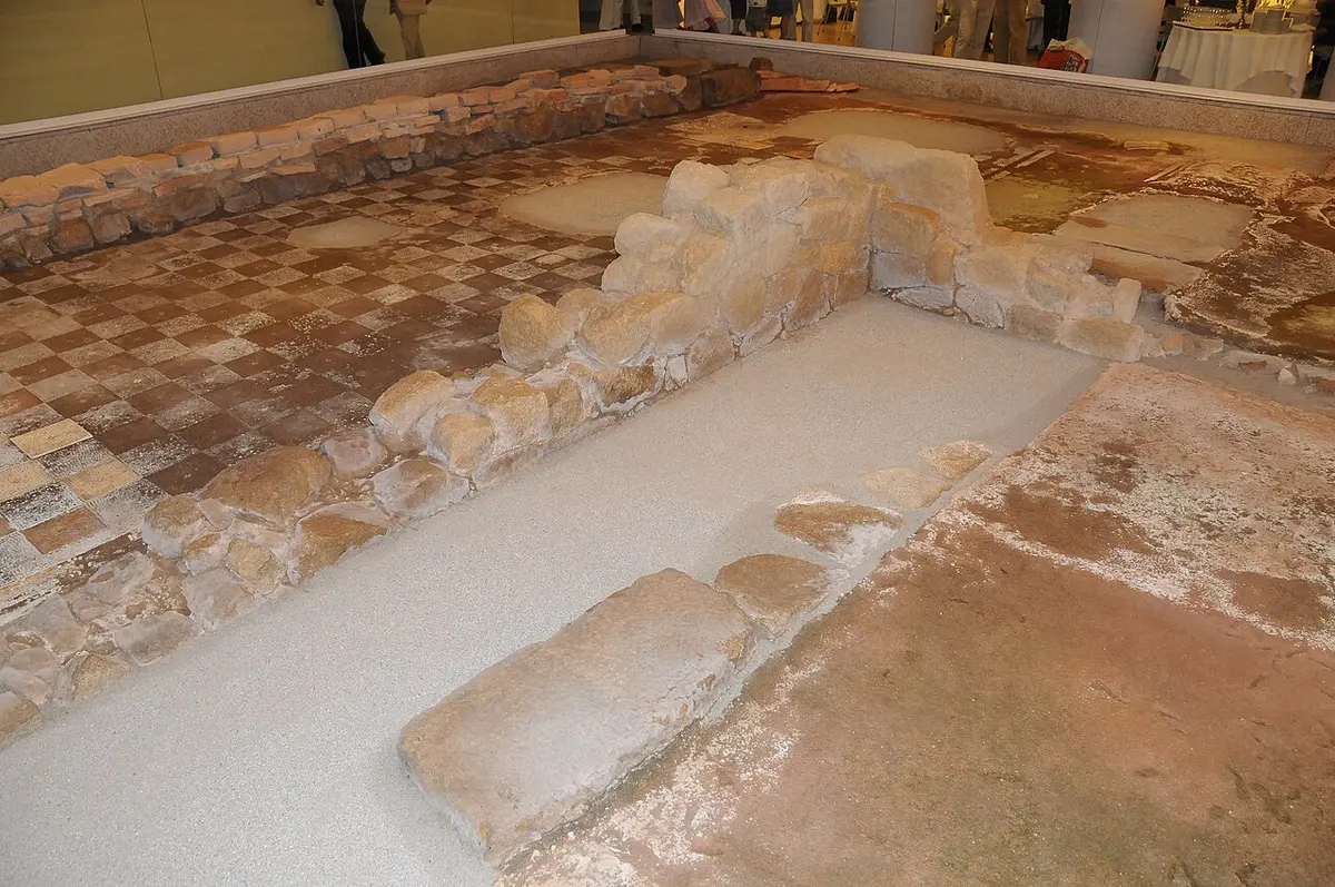 Vestígios arqueológicos com muros de pedra e mosaico romano expostos no interior do museu