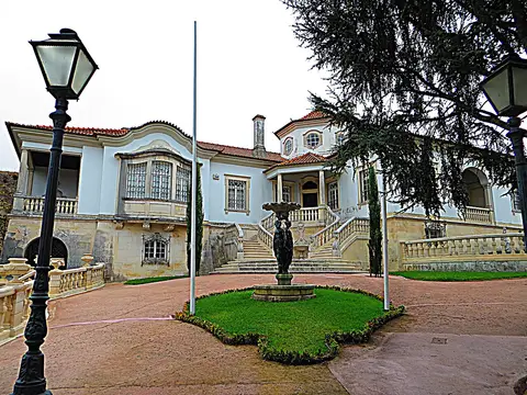 Fachada da Casa Museu Bissaya Barreto com escadaria, fonte e jardim relvado em frente.