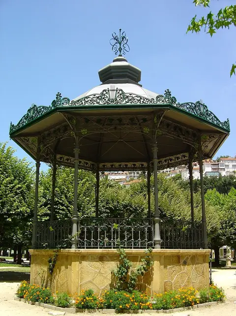 Coreto de ferro forjado rodeado de flores e árvores no Parque Doutor Manuel Braga, em Coimbra