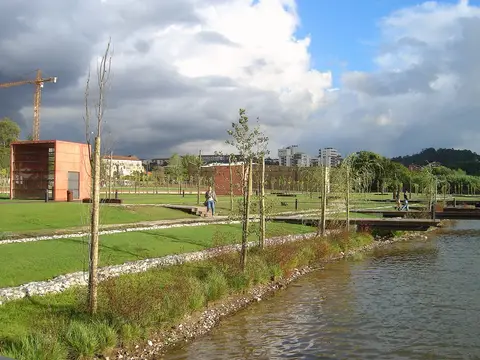 Parque Verde do Mondego em Coimbra, com relvados, árvores jovens e passadiços junto ao rio