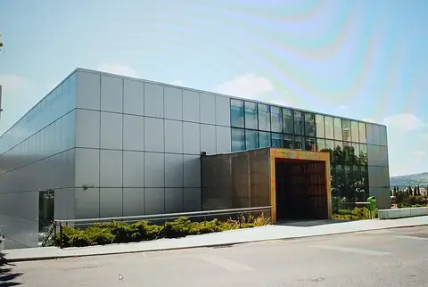 Edifício moderno da Biblioteca Municipal José Saramago, com fachada cinzenta e envidraçada