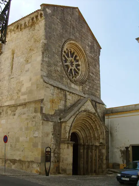 Fachada em pedra da Igreja de São João de Alporão, com rosácea e portal gótico em arco.