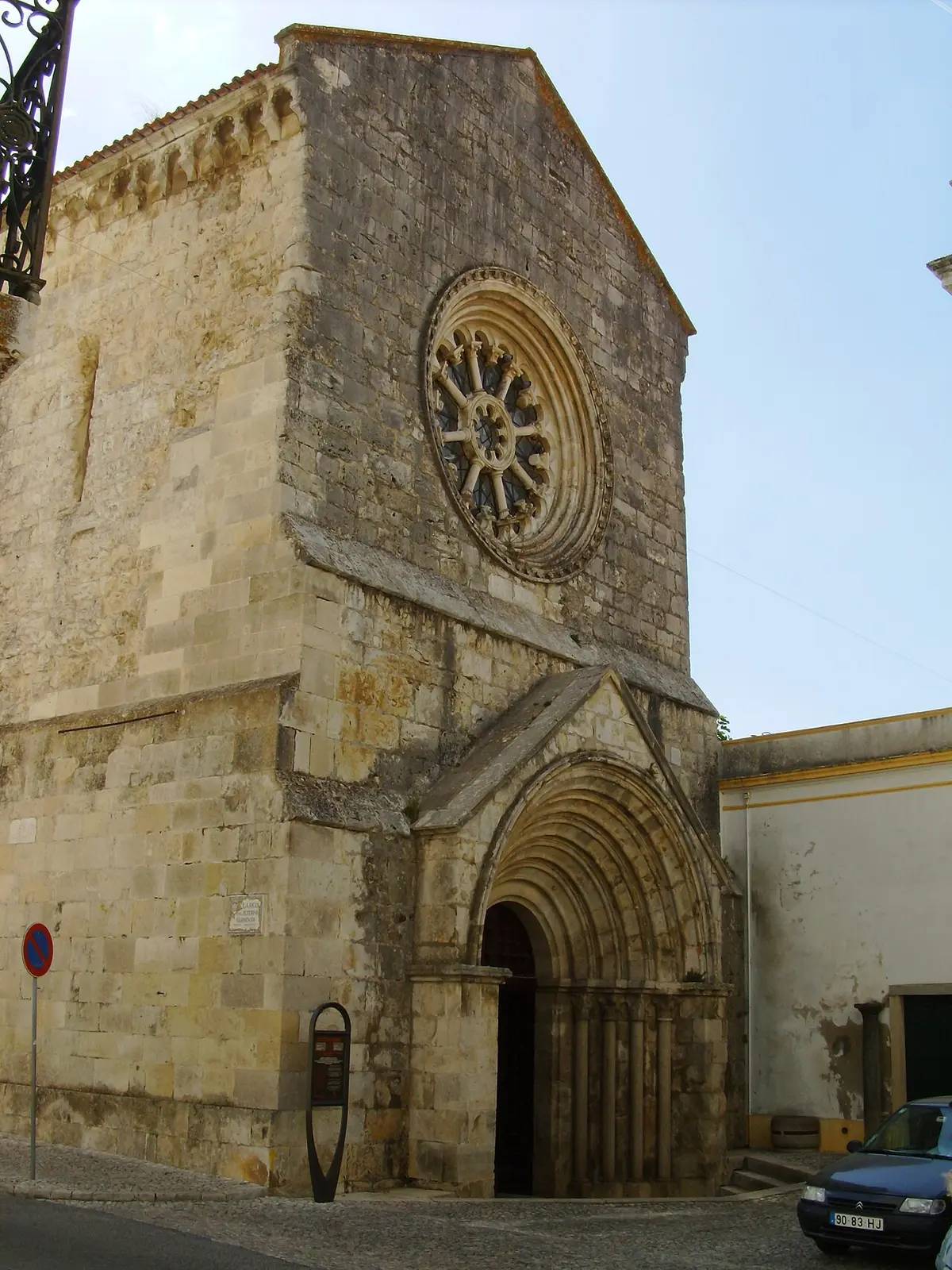 Fachada em pedra da Igreja de São João de Alporão, com rosácea e portal gótico em arco.