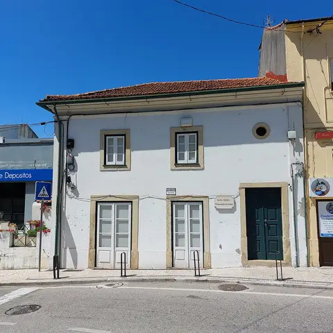 Fachada branca da Casa Museu Fernando Namora, com placa identificativa e portas verdes.